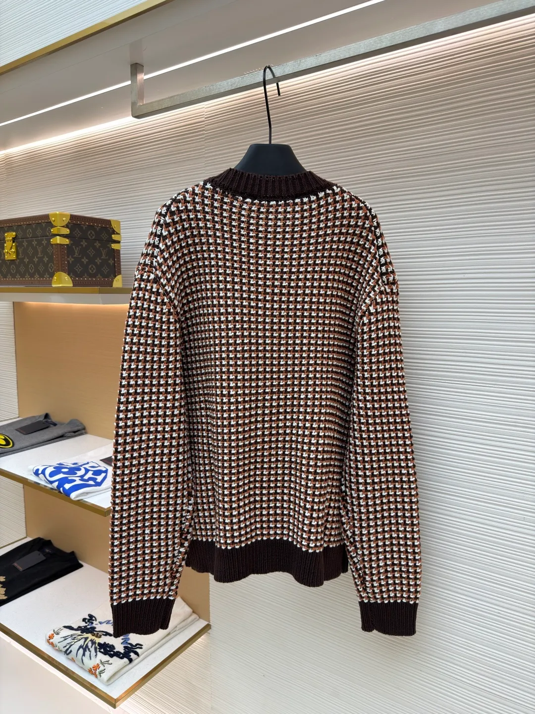 LOUIS VUITTON Thick needle houndstooth color block jacquard pearl button knitted cardigan ●Item number: 1682237-B95 ●Material: wool blended fabric ●Technology: knitted jacquard production ●Color: pattern ●Version: fitted version ●Weight: about 1220 grams ●Size: S-M-L-XL ●Description: This houndstooth knitted cardigan is woven with worsted wool blended yarn. It uses double-ply threading technology to make the yarn tighter. It uses yarn-dyed jacquard technology to create a classic houndstooth pattern. The pattern is clear and symmetrical, with natural color transitions and is not easy to fade. The body of the garment uses a four-knit knitting process. The fabric has high density, good elasticity, and good warmth retention and anti-pilling properties. The neckline, cuffs and hem are designed with ribbed edges and are made of high-elastic spandex blended ribs, which will not easily loosen and deform after long-term wear. The placket is equipped with matte mother-of-pearl buttons, which are hand-polished and polished for a warm texture. The overall design adopts three-dimensional tailoring, and the stitching between the shoulders and body uses embedded clip technology. The stitching is smooth and has no bulges. The spacing of each stitch is precisely controlled, and the exquisite knitting craftsmanship and ingenuity are displayed in every detail. The overall wiring is straight and delicate, the fabric is comfortable and soft, and the color is consistent without color difference. It can be matched with the same style to create a fashionable look and control various occasions. Customized accessories, complete with three standards, same style for men and women!